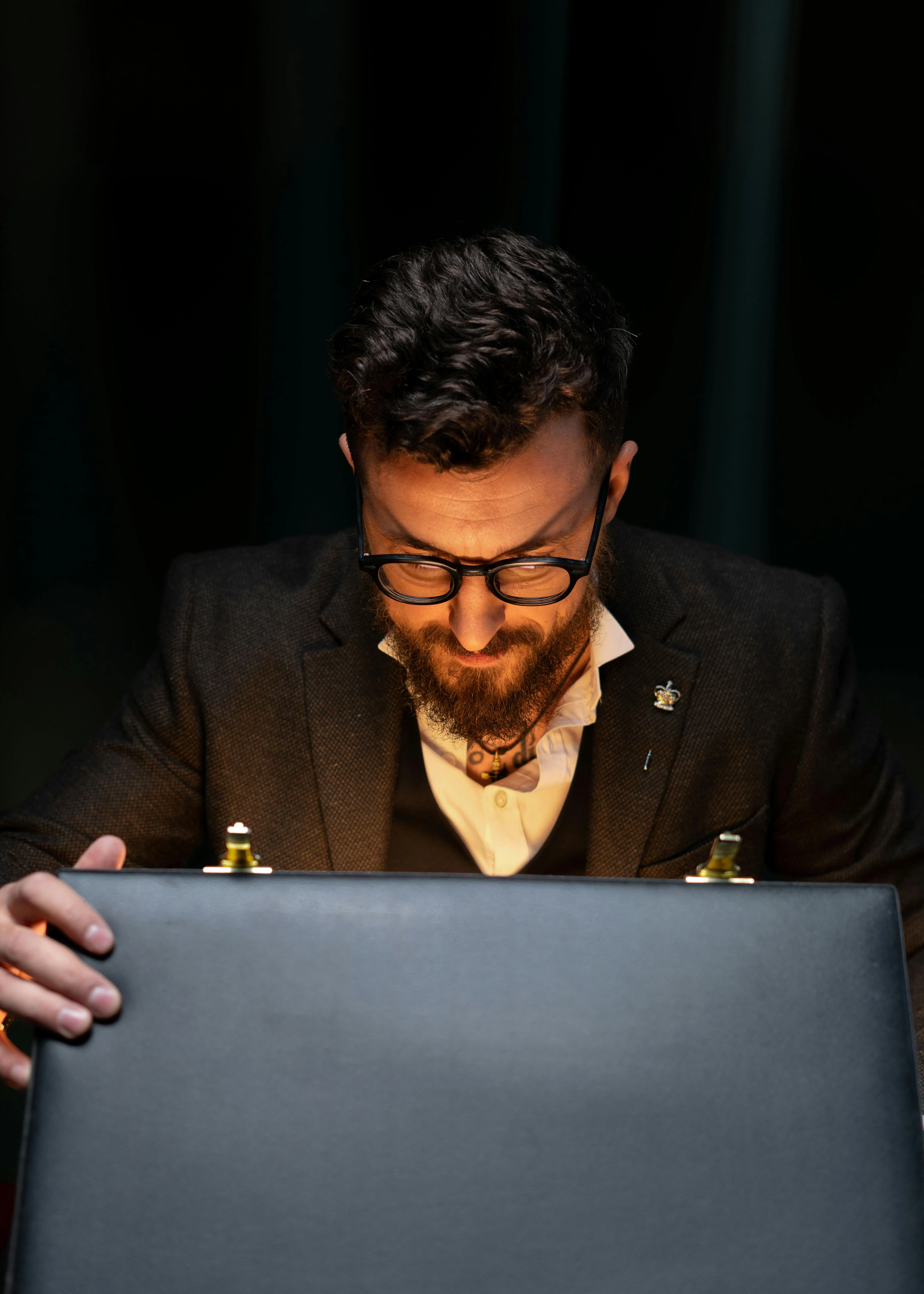 A man opens a briefcase revealing a glowing treasure inside