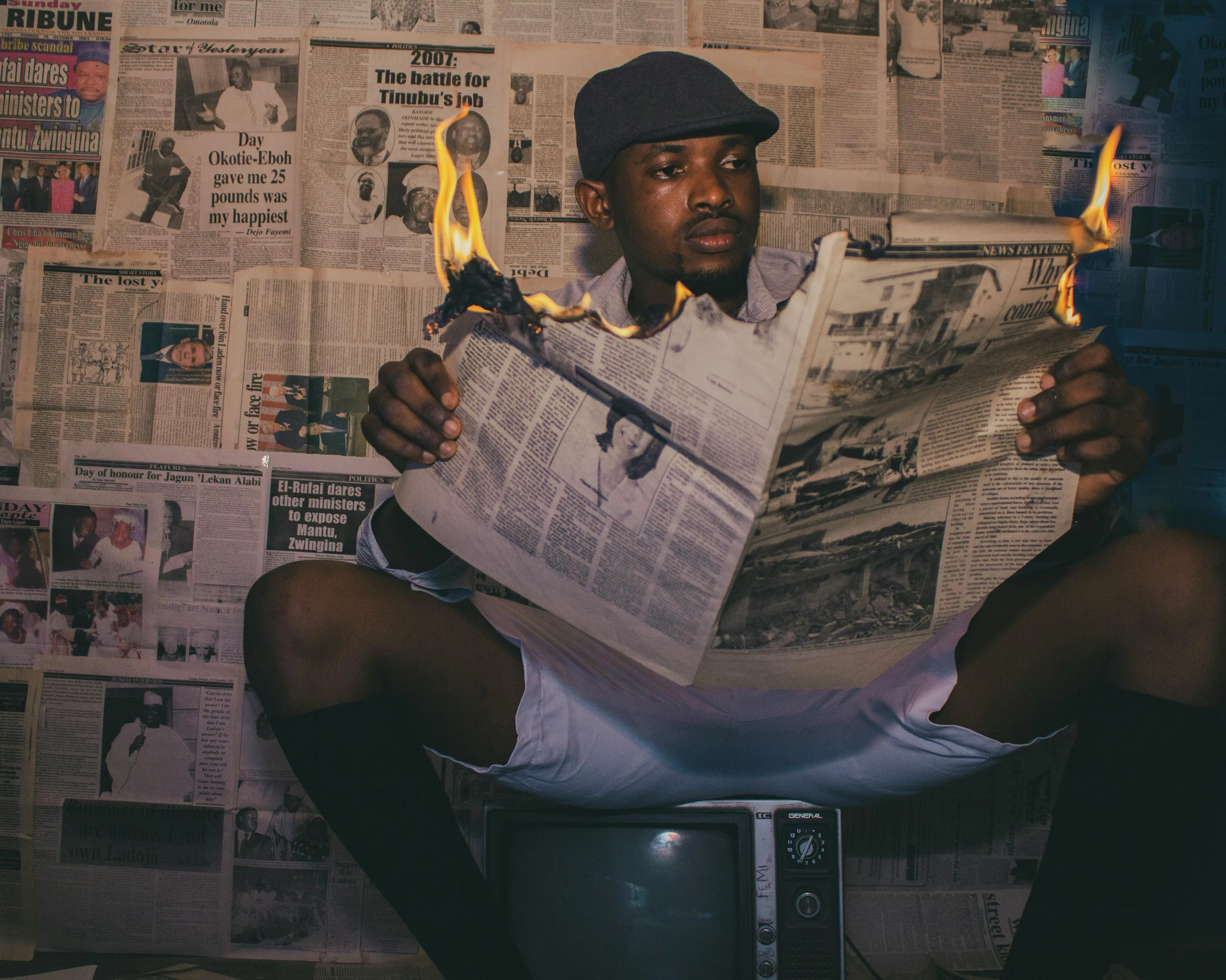 A man reading a burning newspaper